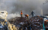 Emergency personnel extinguish a fire at the site of strikes that hit a building next to the Iranian embassy in Syria's capital Damascus, April 1, 2024. (Louai Beshara/AFP)