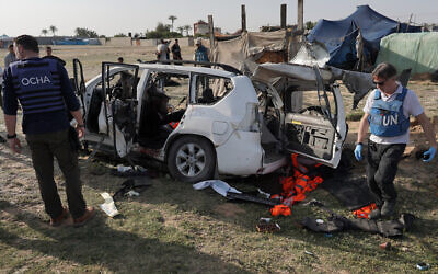 United Nations staff members inspect the remains of a car used by US-based aid group World Central Kitchen hit by an Israeli strike the previous day in Deir al-Balah in the central Gaza Strip on April 2, 2024. (AFP)