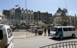 Vehicles drive past the cordoned-off Iranian Embassy building as workers remove the rubble of a consular annex a day after it was hit in a strike in Damascus, Syria, April 2, 2024. (Louai Beshara/AFP)