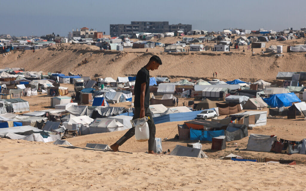 A Palestinian man ferries water at a makeshift camp for displaced people in Rafah in the southern Gaza Strip on April 4, 2024 (Mohammed Abed/AFP) A Palestinian man ferries water at a makeshift camp for displaced people in Rafah in the southern Gaza Strip on April 4, 2024 (Mohammed Abed/AFP)