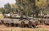 Israeli soldiers gather around army tanks stationed in an area along the border with the Gaza Strip in southern Israel on April 10, 2024. (Jack Guez / AFP)