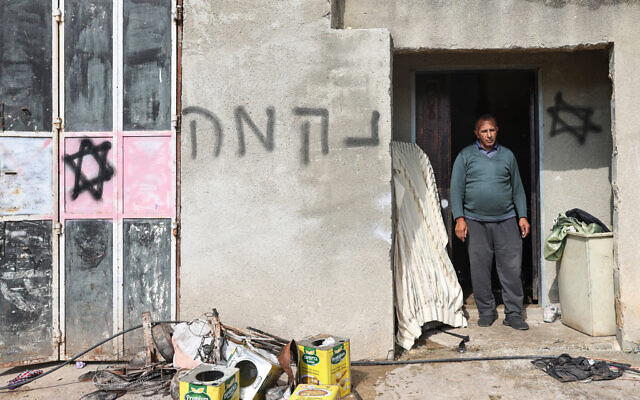 A slogan saying 'revenge' in Hebrew and graffiti bearing Stars of David are pictured on the wall of a Palestinian house after a reported attack by Israeli settlers in the village of Al-Lubban ash-Sharqiya, south of Nablus in the West Bank, on April 11, 2024. (Photo by Zain JAAFAR / AFP)