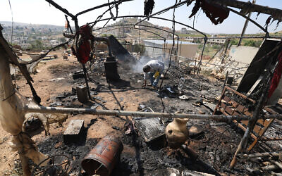 A Palestinian inspects the damage to his belongings in the village of Mughayir near Ramallah in the West Bank on April 13, 2024, after an alleged attack by Israeli settlers on the village. (Jaafar Ashtiyeh / AFP)