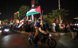 Demonstrators wave Iran's flag and Palestinian flags as they gather at Palestine Square in Tehran on April 14, 2024. (Atta Kenare/AFP)