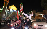 Demonstrators wave Iran's flag and Palestinian flags as they gather at Palestine Square in Tehran on April 14, 2024, after Iran launched a drone and missile attack on Israel. (Atta Kenare / AFP)
