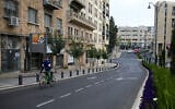 A man rides a bicycle along a Jerusalem street on April 14, 2024. (Ronaldo Schemidt/AFP)