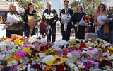 Australian Prime Minister Anthony Albanese (C) stands with New South Wales Premier Chris Minns (4th R) and other officials as they prepare to leave flowers outside the Westfield Bondi Junction shopping mall in Sydney on April 14, 2024. (DAVID GRAY / AFP)