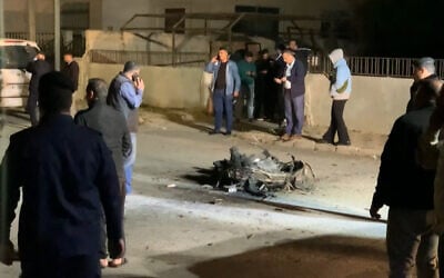 An image grab from AFPTV footage shows Jordanian onlookers and security agents standing around the debris of a missile that the Jordanian forces intercepted over Amman amid an unprecedented Iranian drone and missile attack on Israel in the early hours of April 14, 2024. (Ahmad SHOURA / AFP)