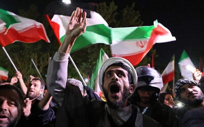 Demonstrators wave Iranian and Palestinian flags as they gather in front of the British Embassy in Tehran on April 14, 2024, after Iran launched a drone and missile attack on Israel.(Atta Kenare/AFP)