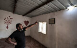 Muhammad Hassouna points to a hole in the roof of a building caused by a projectile that injured his 7-year-old daughter Amina at their Bedouin village, in the southern Negev desert, on April 14, 2024. (Ahmad Gharabli/AFP)