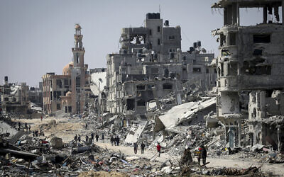People walk amid the rubble of buildings destroyed during the Israeli bombardment of Khan Yunis, in the southern Gaza Strip, on April 16, 2024.,(Photo by AFP)