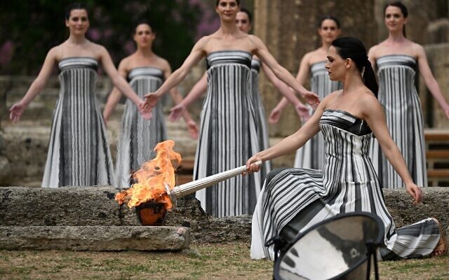 Greek actress Mary Mina, playing the role of the High Priestess, lights the torch during the flame lighting ceremony for the Paris 2024 Olympics Games at the ancient temple of Hera on the Olympia archeological site, birthplace of the ancient Olympics in southern Greece, on April 16, 2024. (Aris Messinis/AFP)