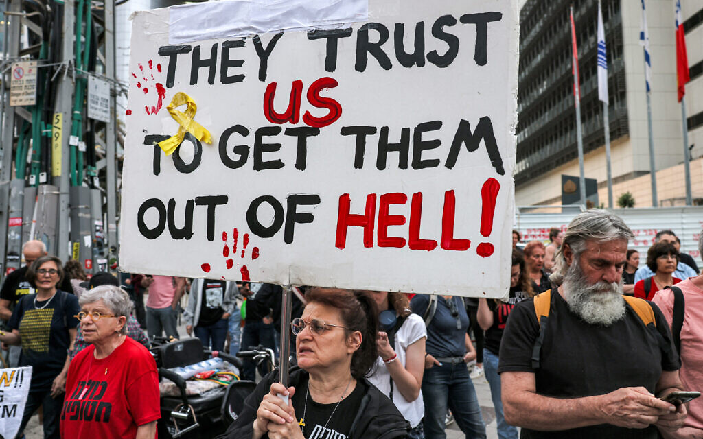 Protesters hold signs calling for the release of hostages held by terror groups in Gaza since October 7, outside the Kirya military base, Tel Aviv, April 18, 2024. (Ahmad Gharbli/AFP)