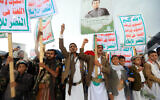 File: Yemenis lift placards and Palestinian flags as they march in the Houthi-run capital Sana'a on April 19, 2024. (Mohammed Huwais/AFP)