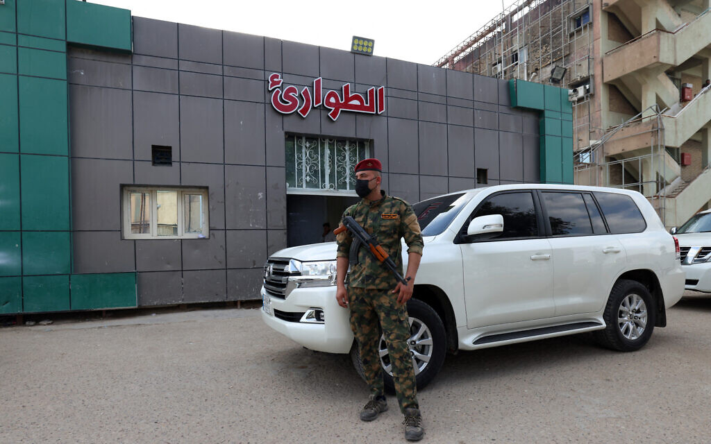 A soldier stands guard at the entrance of the emergency ward of a hospital in Hilla in the central Iraqi province of Babylon where people wounded in an alleged bombing overnight on an Iraqi military base housing a coalition of pro-Iranian armed groups are being treated, on April 20, 2024 (Karar Jabbar / AFP)