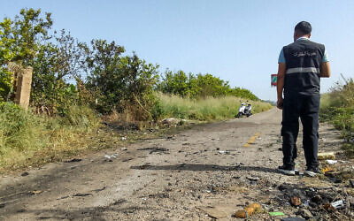 A member of the Lebanese intelligence service stands at the site of an Israeli strike on a vehicle in the Aadloun plain area, between Lebanon's southern cities of Sidon and Tyre, on April 23, 2024. (Mahmoud ZAYYAT / AFP)
