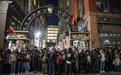 Pro-Palestinian, anti-Israel activists and students from Emerson College block an alley where they have set up an encampment as police move in to clear it, in Boston, Massachusetts, on April 25, 2024. (Joseph Prezioso / AFP)