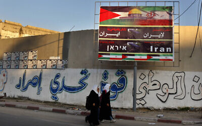 FILE - In this file photo from November 2012, Palestinian school girls pass a billboard covered by Palestinian and Iranian flags with Arabic that reads, "thanks and gratitude to Iran," in Gaza City. (AP Photo/Adel Hana, File)
