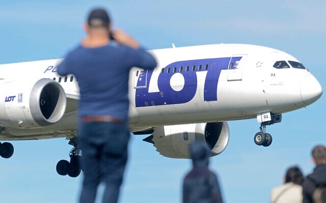 FILE - Plane spotters watch a Polish Airlines LOT jetliner land at the Frederic Chopin airport in Warsaw, Poland, on September 30, 2018. (AP Photo/Alik Keplicz, File) FILE - Plane spotters watch a Polish Airlines LOT jetliner land at the Frederic Chopin airport in Warsaw, Poland, on September 30, 2018. (AP Photo/Alik Keplicz, File)
