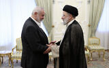 In this photo released by the Iranian Presidency Office, Iranian President Ebrahim Raisi, right, shakes hands with Hamas chief Ismail Haniyeh at his office in Tehran, Iran, March 27, 2024. (Iranian Presidency Office via AP)