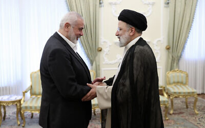 In this photo released by the Iranian Presidency Office, Iranian President Ebrahim Raisi, right, shakes hands with Hamas chief Ismail Haniyeh at his office in Tehran, Iran, March 27, 2024. (Iranian Presidency Office via AP)