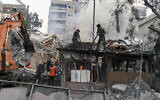 In this photo released by the official Syrian state news agency SANA, emergency service workers clear the rubble at a destroyed building allegedly struck by Israeli jets in Damascus, Syria, Monday, April 1, 2024. (SANA via AP)