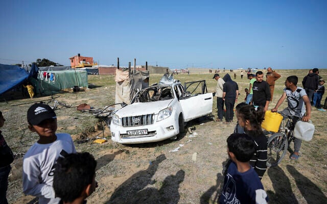 People inspect the site where World Central Kitchen workers were killed in an Israeli air strike in Deir al-Balah, Gaza Strip, Tuesday, April 2, 2024. (AP Photo/Abdel Kareem Hana)