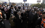 Palestinians wait to cross into Jerusalem from the West Bank on their way to the Al-Aqsa Mosque compound atop the Temple Mount for the last Friday prayers of the Muslim holy month of Ramadan, at the Qalandia checkpoint, April 5, 2024. (AP/Majdi Mohammed)