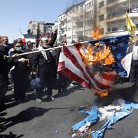 Iranian demonstrators burn US and Israeli flags during an annual rally to mark Quds Day, or Jerusalem Day, in support of Palestinians and against Israel, in Tehran, Iran, Friday, April 5, 2024. (AP Photo/Vahid Salemi)