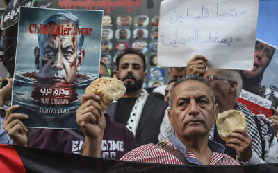 Egyptian activists hold bread as they participate in a pro-Palestinian protest outside the building of the Journalist Syndicate in Cairo, Egypt, Wednesday, April 3, 2024.  (AP Photo/Mohamed El Raai)
