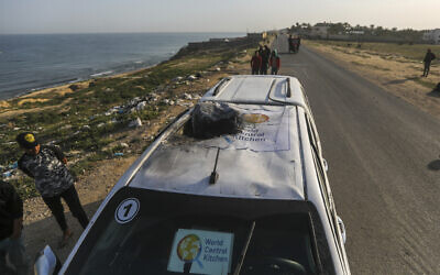 Palestinians inspect a vehicle with the logo of the World Central Kitchen wrecked by an Israeli airstrike in Deir al Balah, Gaza Strip,  April 2, 2024. (Ismael Abu Dayyah/AP)