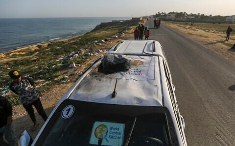 Palestinians inspect a vehicle with the logo of the World Central Kitchen wrecked by an Israeli airstrike in Deir al Balah, Gaza Strip,  April 2, 2024. (Ismael Abu Dayyah/AP)