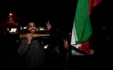 Iranian demonstrators flash the victory sign as they hold an Iranian flag and a model of a bullet during an anti-Israeli gathering at Palestine Square in Tehran, Iran, early Sunday, April 14, 2024. (AP Photo/Vahid Salemi)