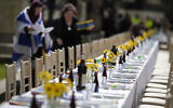 Illustrative: Two women, one of them wrapped in an Israeli flag, help to set the 'The Empty Seder Table,’ with 133 chairs and place settings, representing hostages still being held in Gaza by Hamas, in front of Downing Street in London, Britain, April 17, 2024. (AP Photo/Alastair Grant)