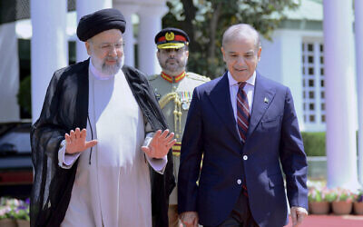 In this photo released by Press Information Department, Iranian President Ebrahim Raisi, left, walks with Pakistan's Prime Minister Shehbaz Sharif in Islamabad, Pakistan on April 22, 2024. (Press Information Department via AP)
