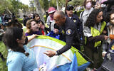 University of Southern California protesters fight with University Public Safety officers as they try to remove tents at the campus' Alumni Park during a pro-Palestinian, anti-Israel occupation in Los Angeles, on April 24, 2024. (Richard Vogel/AP)