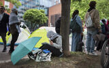 A George Washington University student works on a school assignment while joining other students in protests at George Washington University in Washington,, April 27, 2024. Pro-Palestinian, anti-Israel protests and encampments have sprung up on college and university campuses across the country. (AP Photo/Cliff Owen)