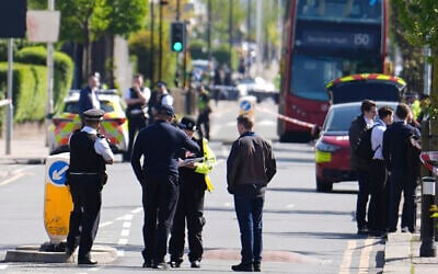 Police talking to members of the public at the scene of a deadly stabbing in Hainault, north east London, April 30, 2024. (Jordan Pettitt/PA via AP)
