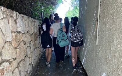 Evacuated students walking down a path at their new school at the Ghetto Fighters' House in Kibbutz Lohamei Hagettaot, March 2024. (Diana Bletter)