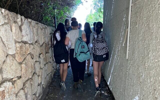 Evacuated students walking down a path at their new school at the Ghetto Fighters' House in Kibbutz Lohamei Hagettaot, March 2024. (Diana Bletter)