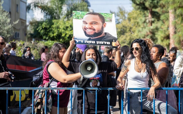 Family members and supporters of Solomon Tekah protest as Haifa Magistrate's Court Judge Zaid Falah and the policeman accused of negligent manslaughter in Tekah's death visit the scene of the incident in Haifa, December 15, 2022. (Shir Torem/Flash90) Family members and supporters of Solomon Tekah protest as Haifa Magistrate's Court Judge Zaid Falah and the policeman accused of negligent manslaughter in Tekah's death visit the scene of the incident in Haifa, December 15, 2022. (Shir Torem/Flash90)