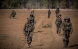 Israeli soldiers from the Netzah Yehuda Battalion patrol near the Israel-Gaza border, October 20, 2023. (Yonatan Sindel/ Flash90)