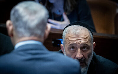 Knesset Member Aryeh Deri looks at Prime Minister Benjamin Netanyahu during a vote on the state budget at the Knesset in Jerusalem, March 13, 2024. (Yonatan Sindel/ Flash90)
