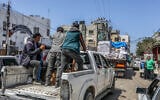 Armed and masked Palestinians seen on trucks loaded with international humanitarian aid entering Gaza through Israel's Kerem Shalom crossing, into southern Gaza on April 3, 2024. (Abed Rahim Khatib/Flash90)