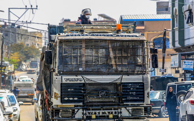 Armed and masked Palestinians seen on trucks loaded with International Humanitarian Aid entering Gaza through the Kerem Shalom Crossing, in the southern Gaza Strip, April 3, 2024. (Abed Rahim Khatib/ Flash90) Armed and masked Palestinians seen on trucks loaded with International Humanitarian Aid entering Gaza through the Kerem Shalom Crossing, in the southern Gaza Strip, April 3, 2024. (Abed Rahim Khatib/ Flash90)