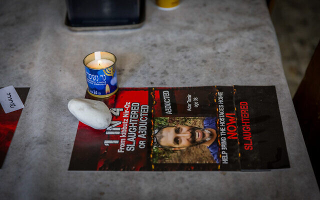 A placard and memorial candle for murdered hostage Tamir Adar at a pre-Passover event in the Kibbutz Nir Oz dining hall on April 11, 2024. (Liron Moldovan/Flash90) A placard and memorial candle for murdered hostage Tamir Adar at a pre-Passover event in the Kibbutz Nir Oz dining hall on April 11, 2024. (Liron Moldovan/Flash90)