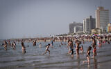 People enjoy the beach in Tel Aviv during a heatwave, on April 24, 2024. (Avshalom Sassoni/Flash90)