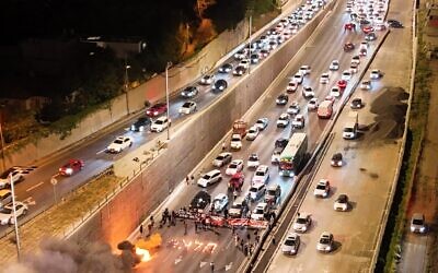 Families of hostages and their supporters block the Ayalon Highway on April 27, 2024, as they demand a deal to release their loved ones. The Hebrew letter spells out the word "Enough. (Amir Goldstein: Pro-Democracy Protest Movement)