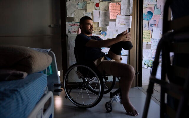 IDF soldier Jonathan Ben Hamou, 22, wounded in the war with Hamas, in his room at Sheba hospital's rehabilitation division, in Ramat Gan, December 18, 2023. (AP/Oded Balilty)