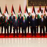 Palestinian Authority President Mahmoud Abbas poses for a picture with his new government, after it was sworn in on March 31, 2024, in Ramallah, in the West Bank. Finance Minister Omar Bitar is standing third from the left in the front row. (Jaafar ASHTIYEH / AFP)